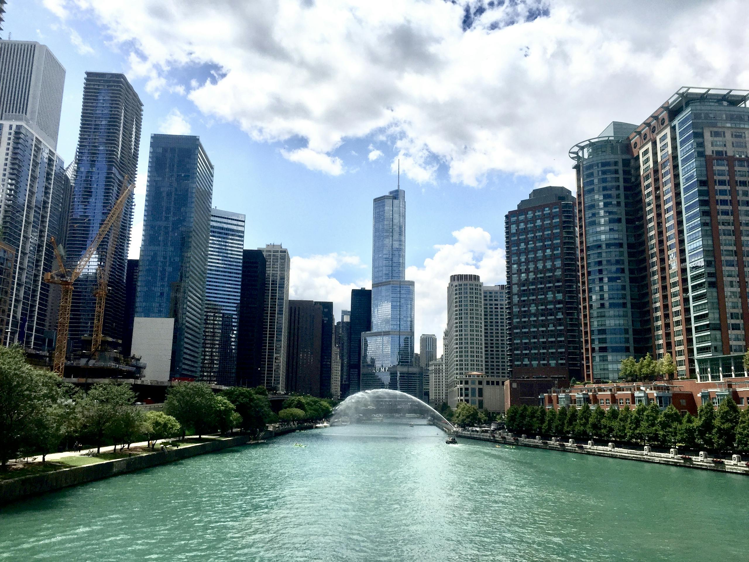 River Between Trees and City Skyscrapers